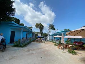 a group of blue buildings with tables and umbrellas at HomeStay2 in Kaôh Rŭng