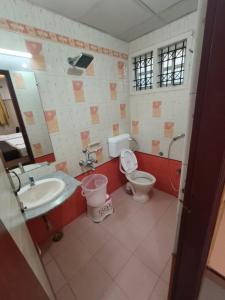a bathroom with a sink and a toilet and a mirror at Anand Regency Majestic in Bangalore +22 photos