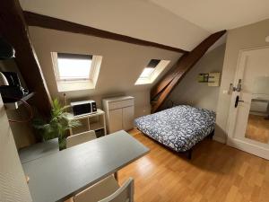 a small room with a table and a bed at Studio rénové gare Dijon in Dijon