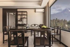 a kitchen with a table and chairs and a large window at 雲幔宋居 in Lijiang