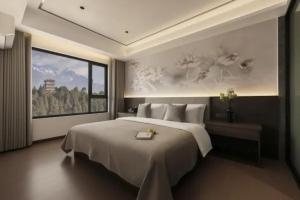 a bedroom with a large bed and a painting on the wall at 雲幔宋居 in Lijiang