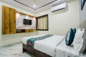 a bedroom with a bed and a tv on the wall at Hotel Prestige Grand, Manikonda in Haidar Sāhibgūda