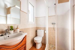 a bathroom with a toilet and a sink and a shower at Villa Santi I by Villa Plus in Cala en Porter +16 photos