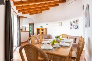 a dining room with a wooden table and chairs at Villa Santi I by Villa Plus in Cala en Porter