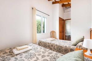 a bedroom with two beds and a window at Villa Santi I by Villa Plus in Cala en Porter