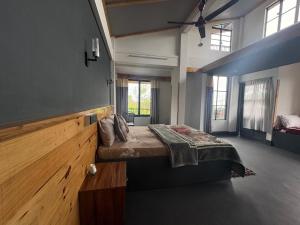 a bedroom with a large bed in a room with windows at West corner B Homestay in Mawlynnong