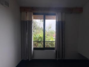 a window with a view of a balcony at West corner B Homestay in Mawlynnong
