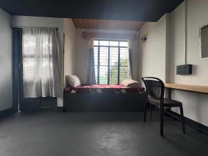 a bedroom with a bed and a chair and a window at West corner B Homestay in Mawlynnong +7 photos