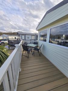 a deck with chairs and a table on a house at Palm trees and the sea in Reighton