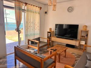a living room with a flat screen tv and a couch at EcoDream Lodge in Abercrombie