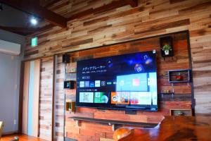a large flat screen tv on a wooden wall at 118 Terrace in Nakijin