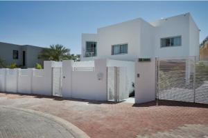 a white fence in front of a white house at Roni Suite in Eilat