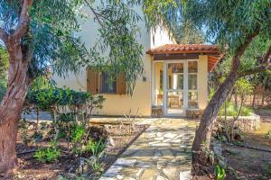 a house with a stone walkway leading to the front door at Astrelis Emerald Villa - Cozy House Walking Distance to the Beach in Kalyves