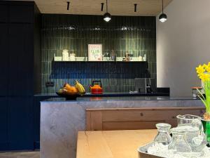 a kitchen with a counter with a bowl of fruit on it at "Unter Freunden", Design Meets Allgäu in Wertach +12 photos