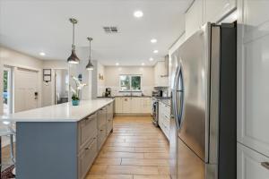 a kitchen with white cabinets and a stainless steel refrigerator at 10 Colonial Drive in Cocoa Beach