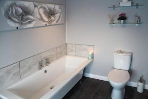 a bathroom with a bath tub and a toilet at The Windmill Inn - Whitby in Whitby