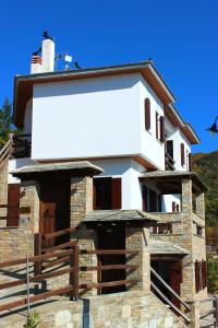 un gran edificio blanco con una valla delante en Archontiko Xantha, en Makrinitsa