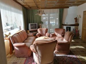 a living room with leather chairs and a television at Gästehaus Gruber in Pusterwald