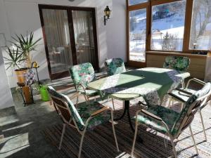 a dining room with a green table and chairs at Gästehaus Gruber in Pusterwald