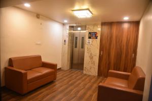 a waiting room with two chairs and a elevator at Sg Happy Stay in Machilīpatnam