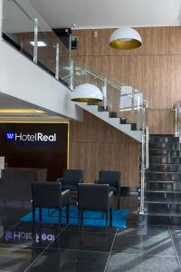 a lobby with chairs and stairs in a building at Hotel Real Executive in Aparecida de Goiania