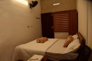 a bedroom with a bed with two stuffed animals on it at Cloud valley wayanad in Vayittiri