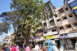 a group of people walking down a busy city street at Hotel Benz Inn in Mumbai