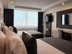 a hotel room with two beds and a desk at Hotel Marbella in Mexico City