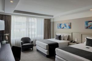 a hotel room with two beds and a chair at Hotel Marbella in Mexico City +84 photos