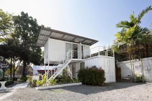 a white house with a staircase on the side of it at serene hotel in Chiang Mai