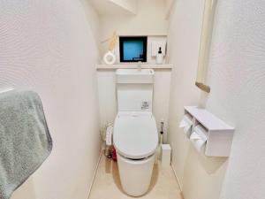 a bathroom with a toilet with a tv above it at Seaside Condo Nagisa House in Chatan +64 photos