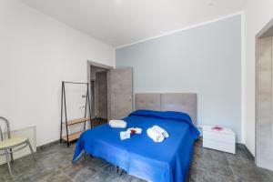 a bedroom with a blue bed with two towels on it at Tenuta VillaMar Rooms in Cursi
