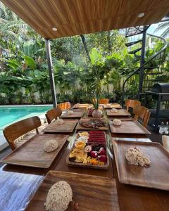 a long wooden table with plates of food on it at Balay nimo by Sachzna in Amadeo