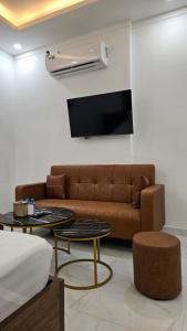a living room with a brown couch and two tables at The Moon Hotel in Chánh Long
