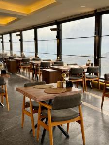 a restaurant with tables and chairs and large windows at Montana Resort Otel in Trabzon