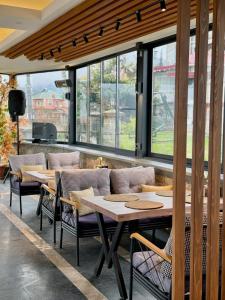 a restaurant with tables and chairs and windows at Montana Resort Otel in Trabzon