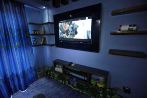 a living room with a tv on a blue wall at Manara Beachfront Chalet Ain Sokhna in Ain Sokhna