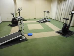 a gym with treadmills and elliptical machines at Kuretake Inn Asahikawa in Asahikawa