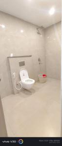 a bathroom with a white toilet in a room at Hotel Peepal in Noida