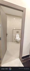 a bathroom with a toilet in a room at Hotel Peepal in Noida