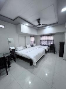 a large bedroom with two beds and a piano at Radha Krishna Guest House in Surat