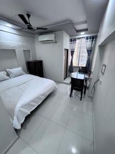 a bedroom with a bed and a table in it at Radha Krishna Guest House in Surat