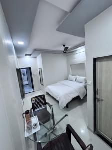 a bedroom with a bed and a desk with a glass table at Radha Krishna Guest House in Surat