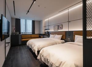 a hotel room with two beds and a flat screen tv at L7 CHUNGJANG by LOTTE HOTELS, formerly Ramada Plaza by Wyndham Chungjang in Gwangju +21 photos