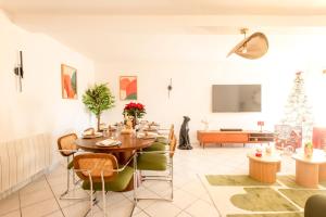 a dining room with a table and a christmas tree at Casa Dina - in Chalon-sur-Saône