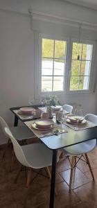 a dining room with a table with plates and chairs at LURRA Tierra Apartamento 1 in Sopuerta +3 photos