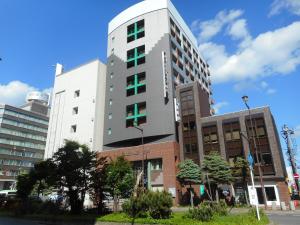 a tall building with a sign on the side of it at Kuretake Inn Asahikawa in Asahikawa