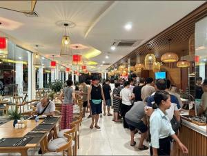 a crowd of people standing in a restaurant at Khu Nghỉ Dưỡng Ivory Villa Resort in Lương Sơn