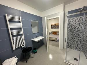 a bathroom with a shower and a sink and a bed at Lotelito Apartment in Fisciano +14 photos