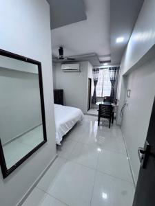 a bedroom with a bed and a table in it at Radha Krishna Guest House in Surat +3 photos